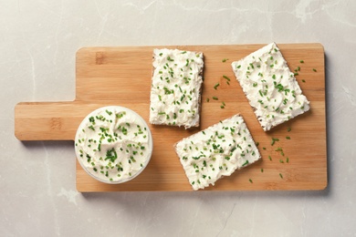 Photo of Tasty snack with cream cheese on gray table, flat lay