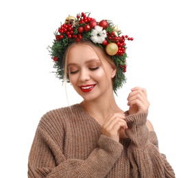 Beautiful young woman wearing Christmas wreath on white background