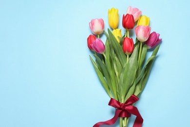 Photo of Beautiful colorful tulips on light blue background, flat lay. Space for text