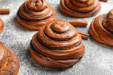 Cinnamon rolls and sugar powder on table, closeup