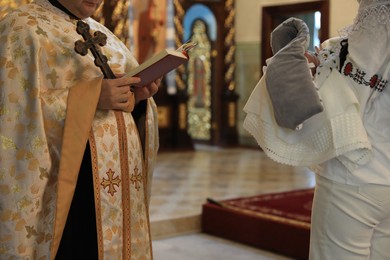 Photo of Stryi, Ukraine - September 11, 2022: Priest conducting baptism ceremony in Assumption of Blessed Virgin Mary cathedral, closeup