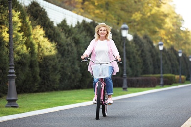 Mature woman riding bicycle outdoors. Active lifestyle