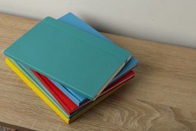 Photo of Stack of colorful planners on wooden table