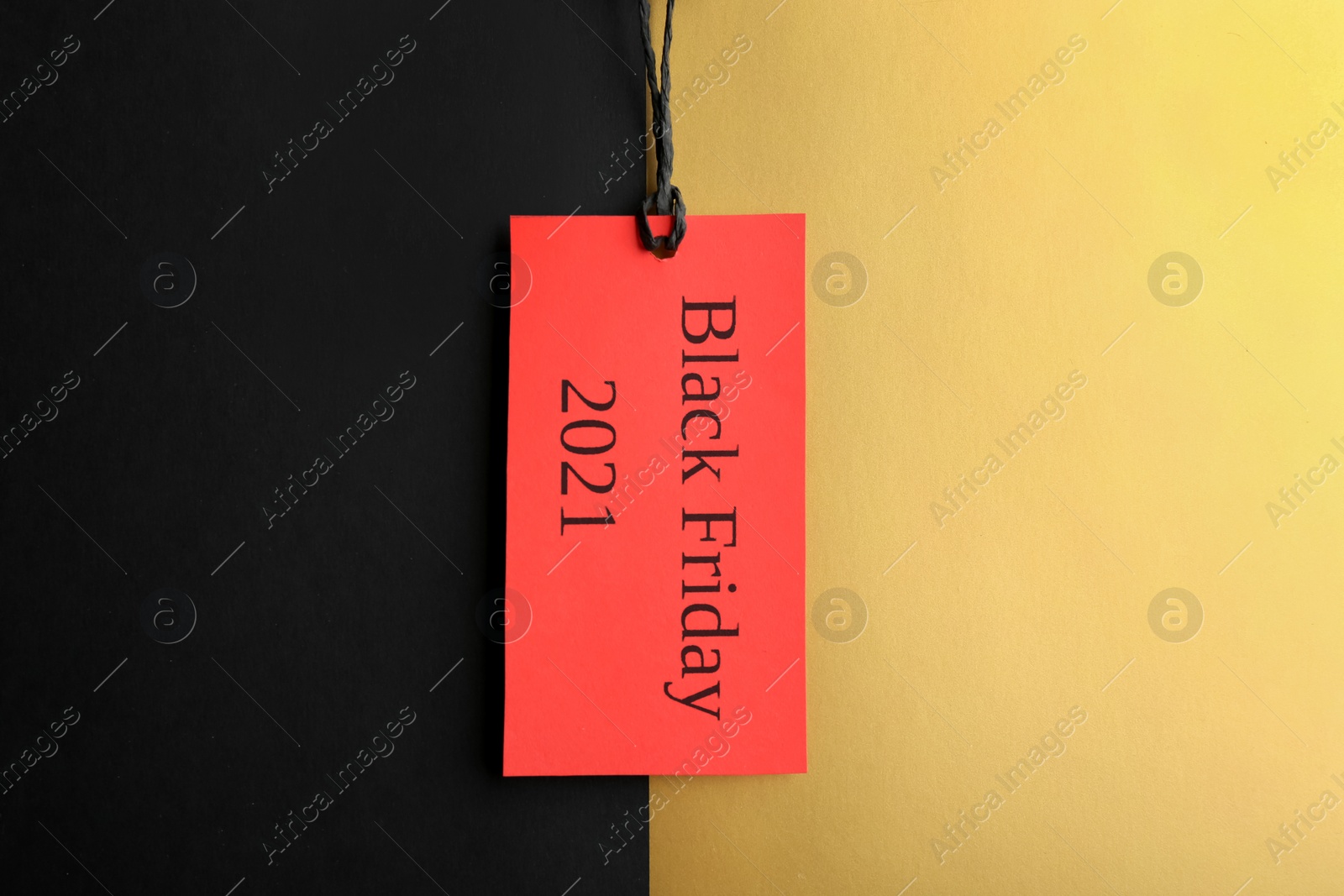 Photo of Tag with words BLACK FRIDAY 2021 on color background, top view