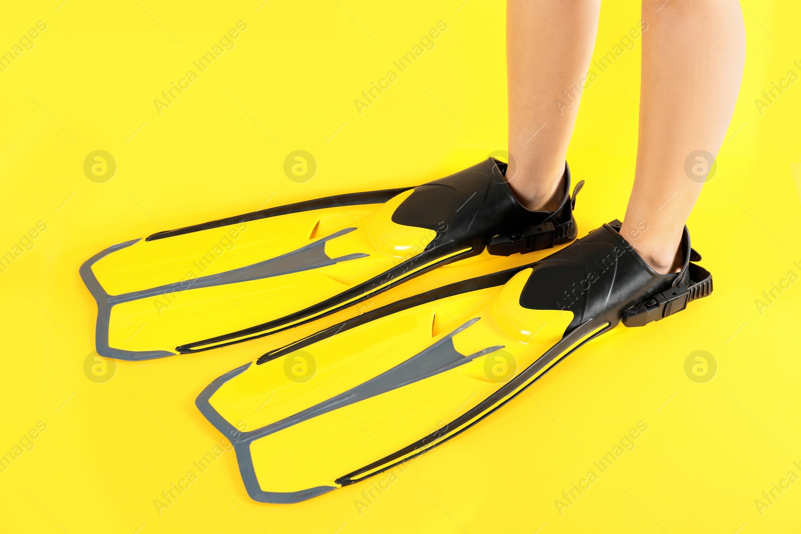 Photo of Woman in swimming flippers on color background, closeup
