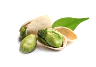 Photo of Tasty organic pistachio nuts and leaf on white background, closeup