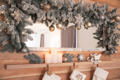 Photo of Burning candles on wooden shelf at home. Christmas interior