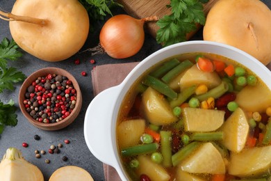 Photo of Bowl of delicious turnip soup on grey table, flat lay