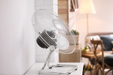 Photo of Modern electric fan on white table indoors