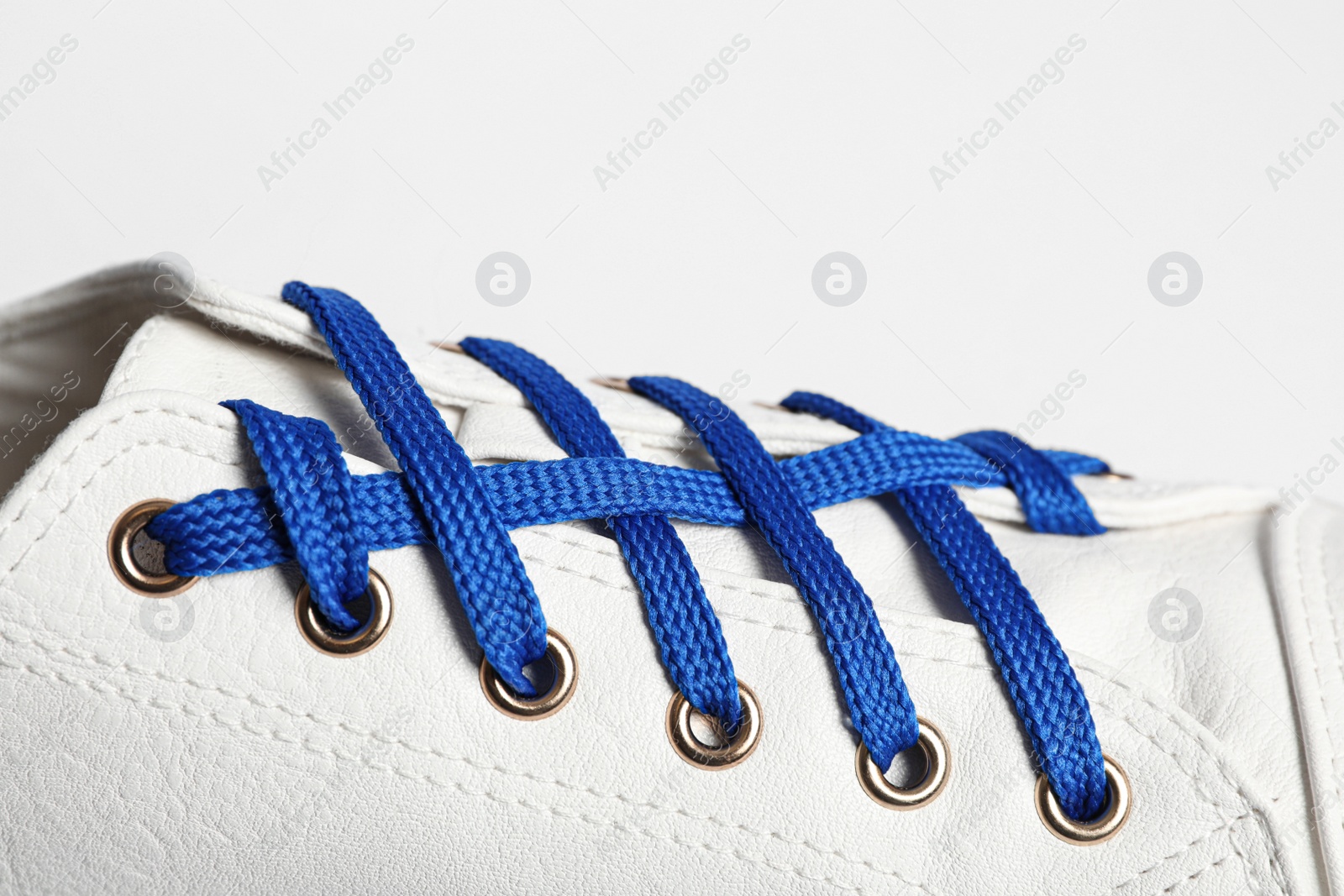 Photo of Stylish shoe with blue laces on white background, closeup