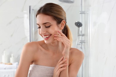 Photo of Young woman with clean fresh skin in bathroom