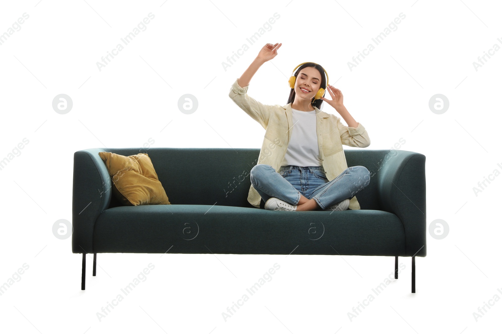 Photo of Young woman listening to music on comfortable green sofa against white background