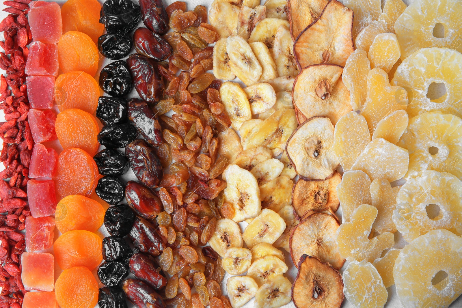 Photo of Different tasty dried fruits as background, top view