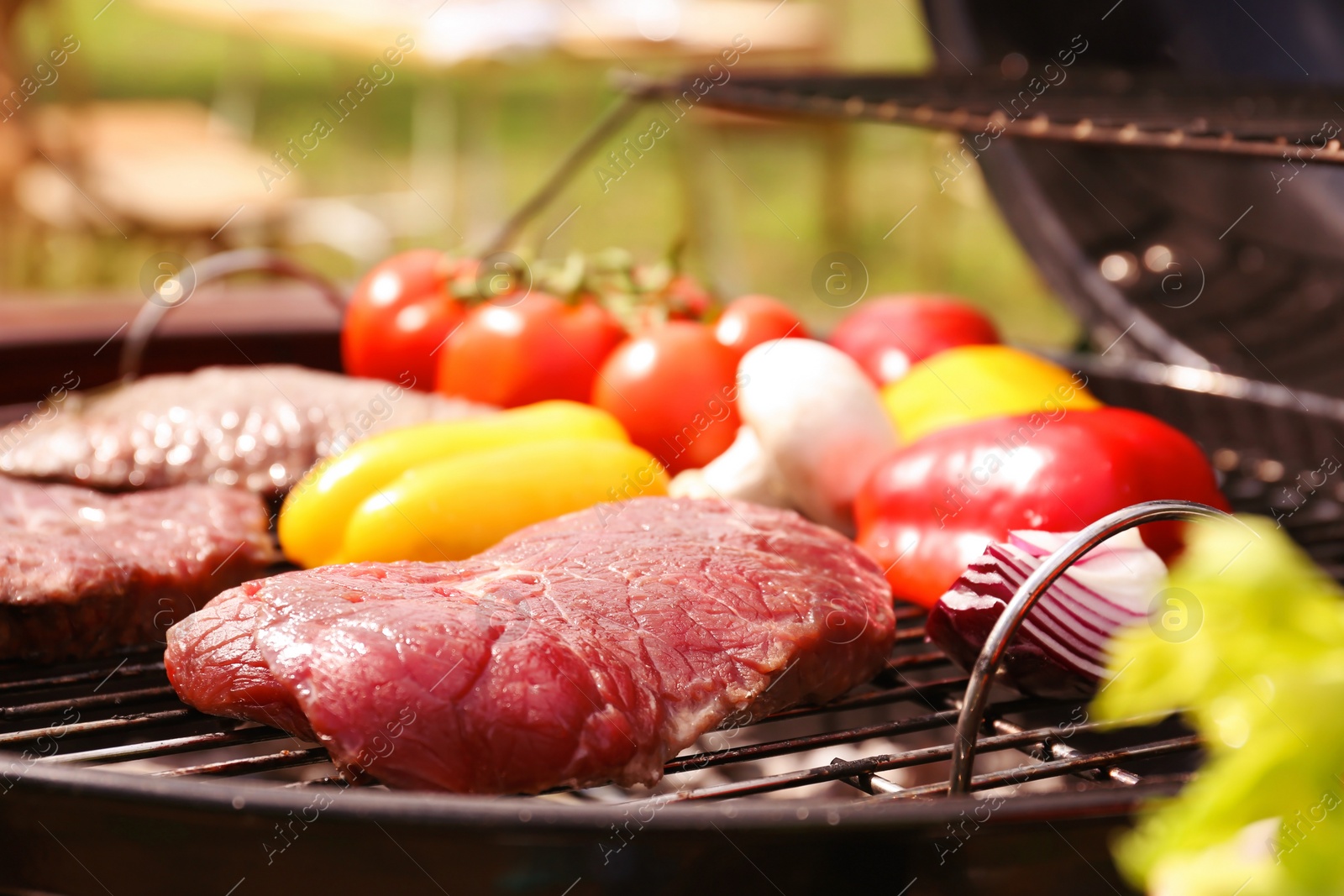 Photo of Modern grill with meat and vegetables outdoors, closeup