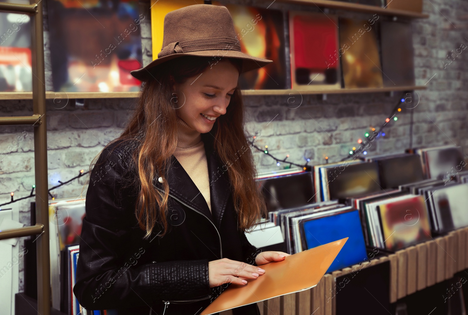 Image of Young woman with vinyl record in store