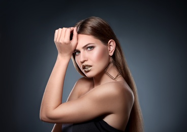 Portrait of beautiful lady with gold lipstick on grey background