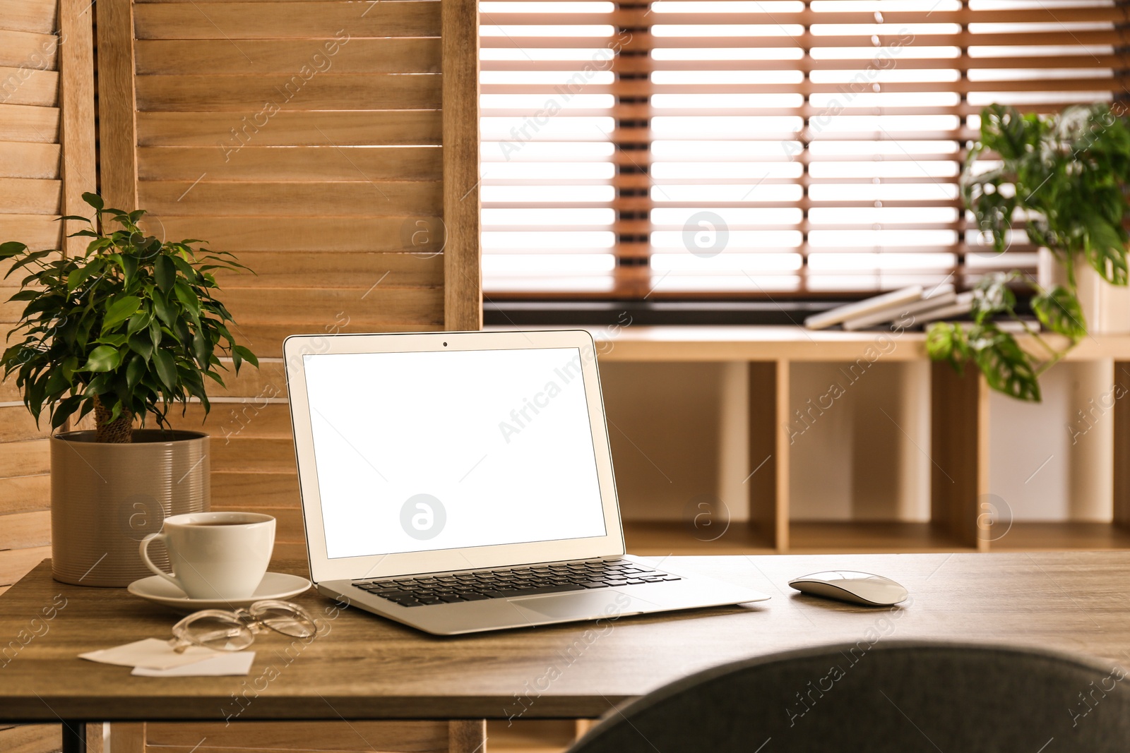 Photo of Modern laptop on table in office. Comfortable workplace