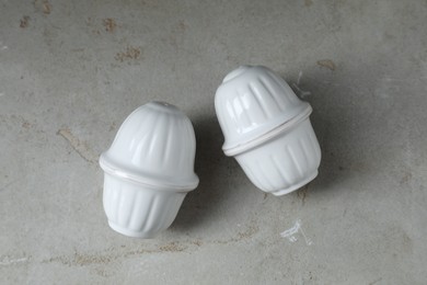 Photo of Salt and pepper shakers on light textured table, top view