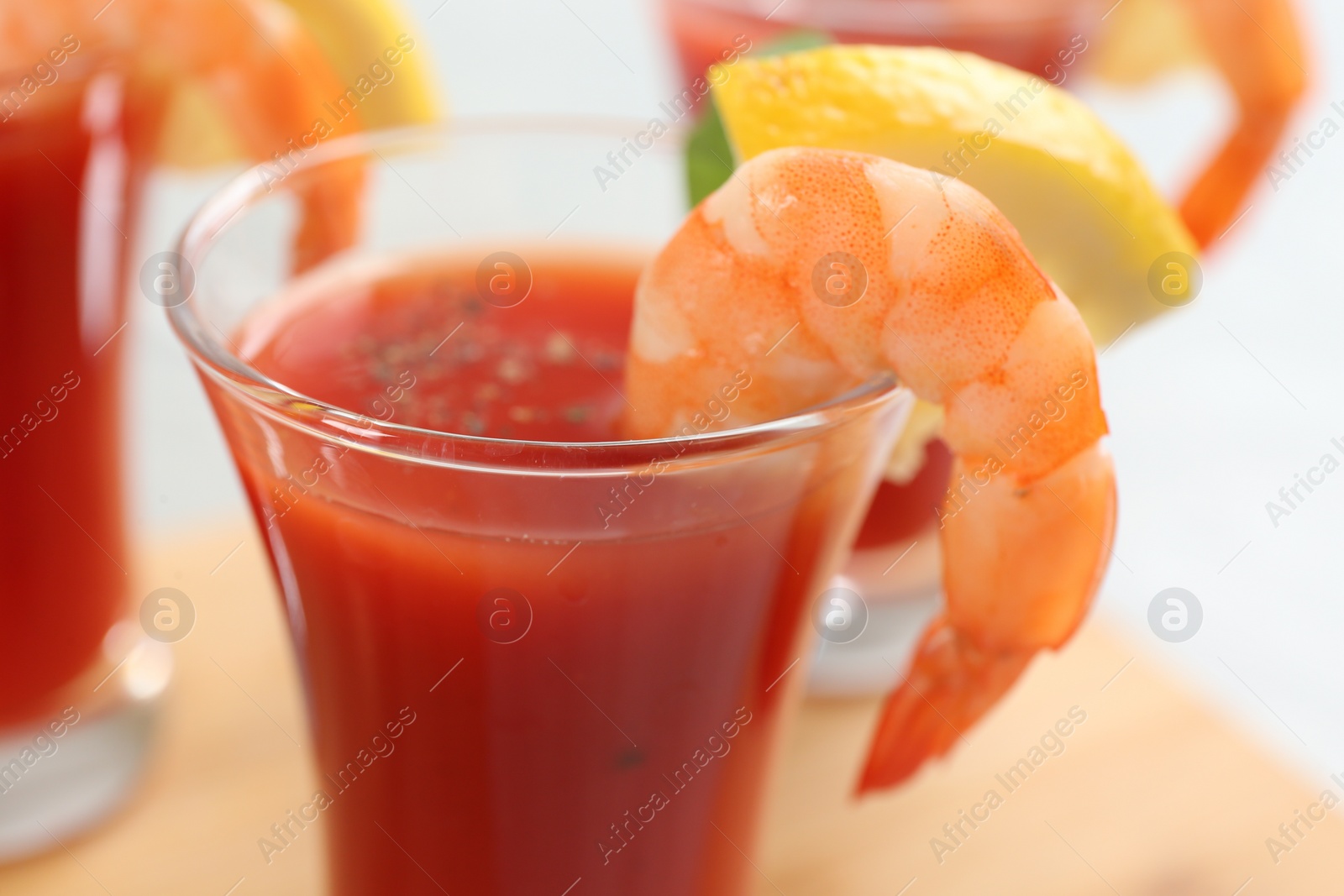 Photo of Delicious shrimp cocktail with tomato sauce served on table, closeup