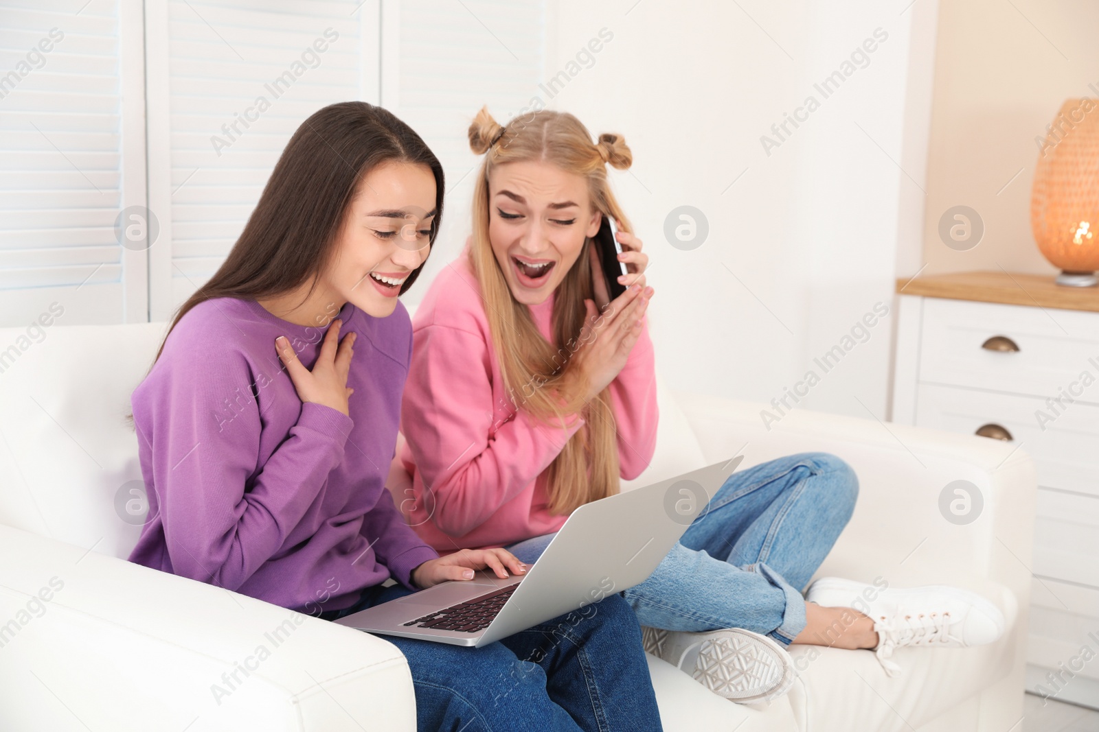 Photo of Young women with laptop laughing at home