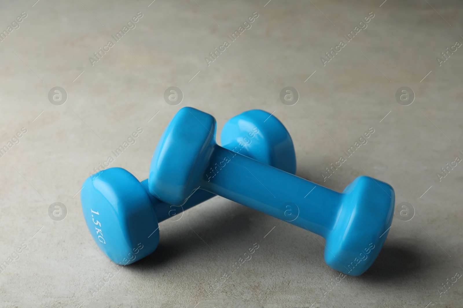 Photo of Blue vinyl dumbbells on light grey table