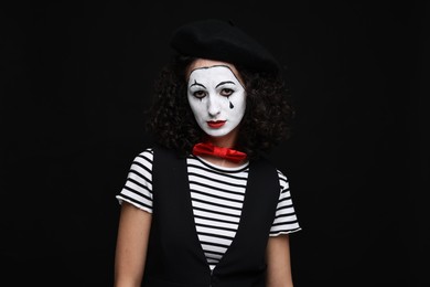 Photo of Young woman in mime costume posing on black background