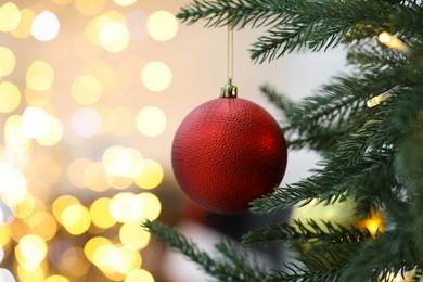 Photo of Closeup of red bauble hanging on Christmas tree, space for text. Bokeh effect