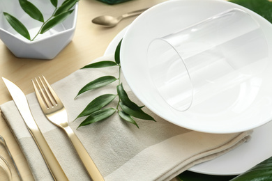 Photo of Elegant table setting with green leaves, closeup