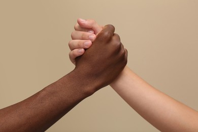 Photo of Men clasping hands on beige background, closeup