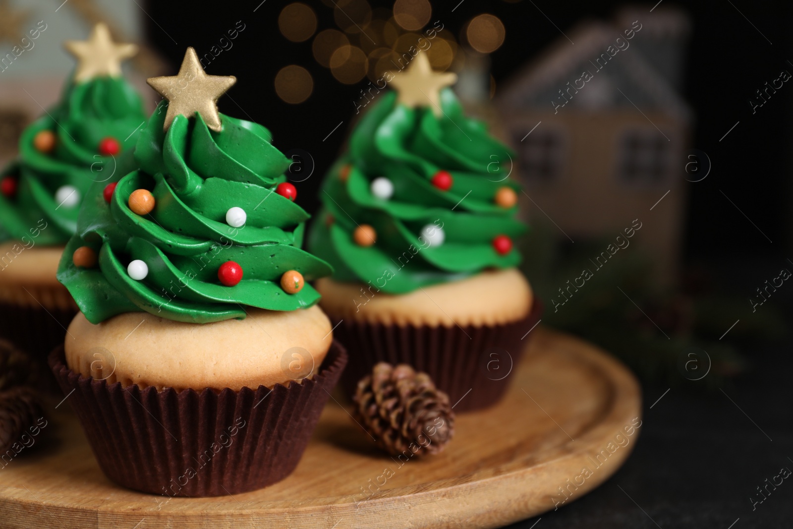 Photo of Christmas tree shaped cupcakes on wooden board, closeup