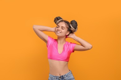 Photo of Beautiful woman with braided double buns on yellow background