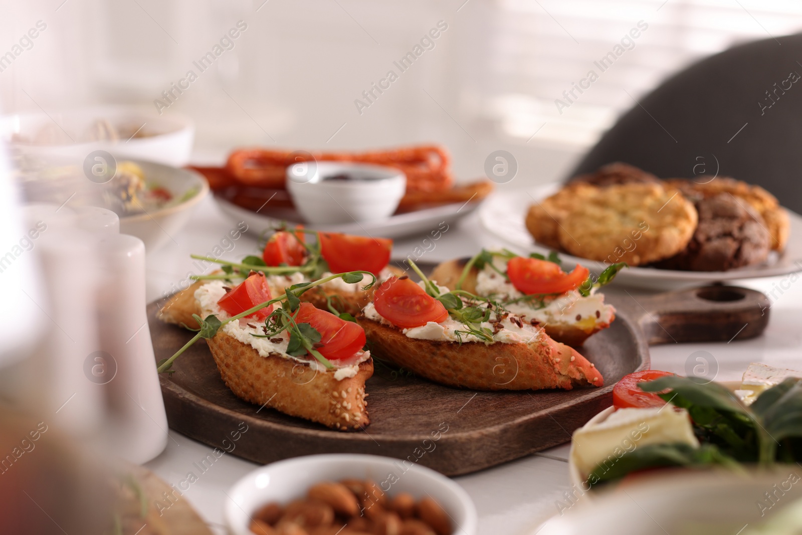 Photo of Delicious sandwiches with cheese and tomatoes served on buffet table for brunch