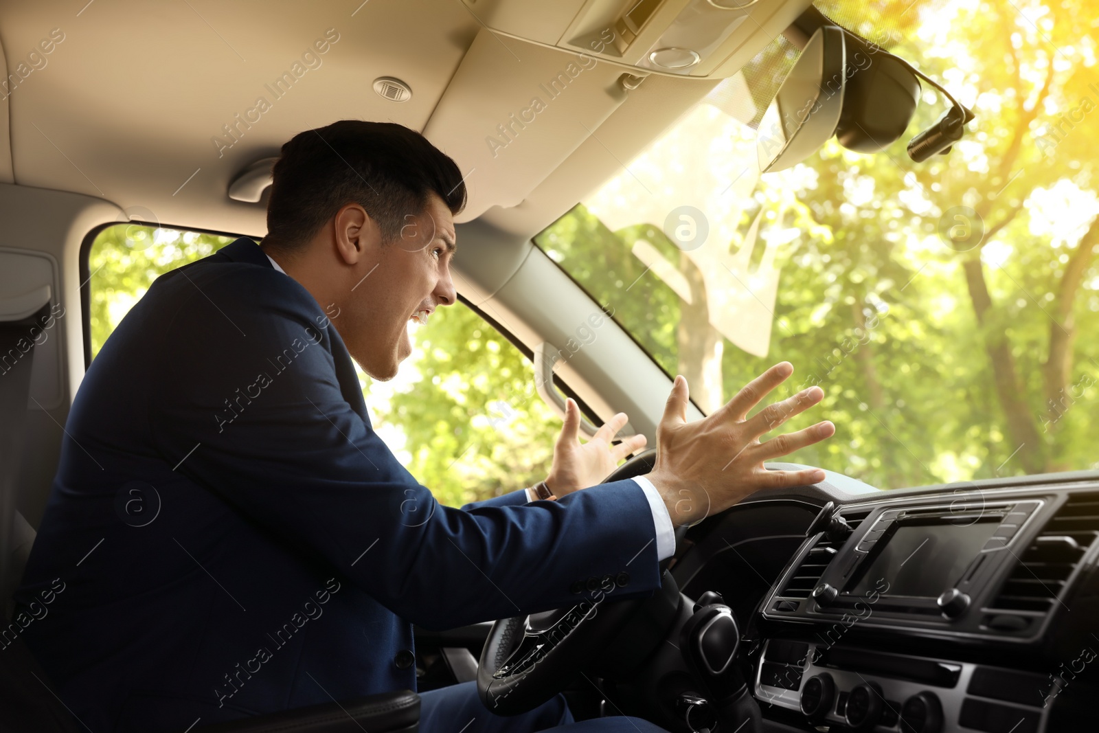 Photo of Emotional man yelling in car. Aggressive driving behavior