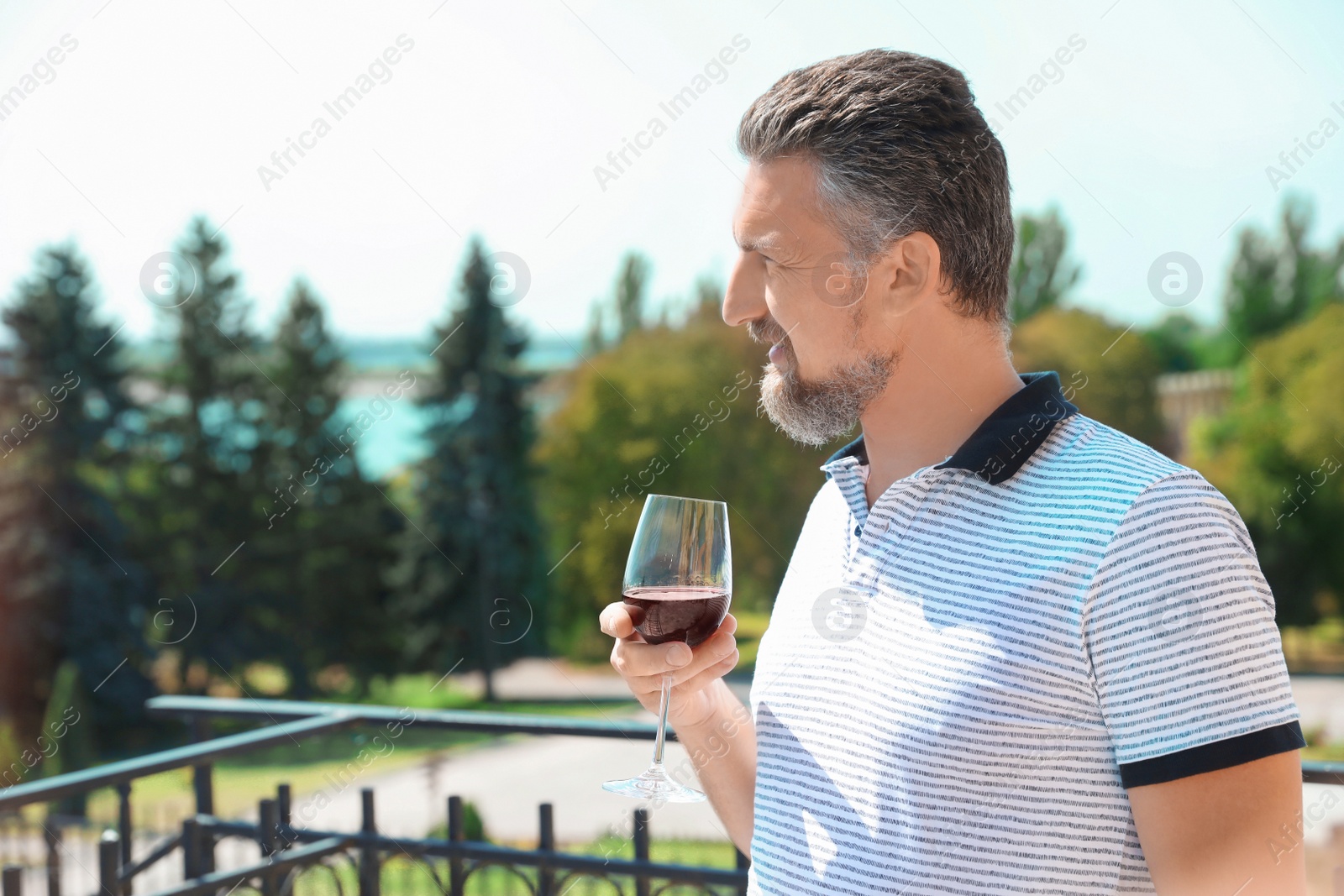 Photo of Man with glass of red wine outdoors