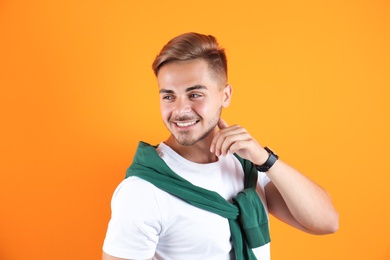 Photo of Young man with trendy hairstyle on color background