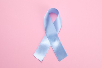 Photo of International Psoriasis Day. Ribbon as symbol of support on pink background, top view