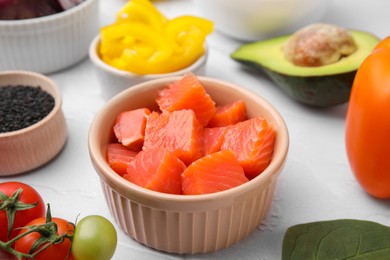 Photo of Ingredients for poke bowl on white textured table, closeup