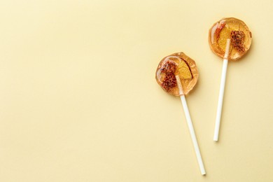 Photo of Sweet colorful lollipops with berries on beige background, flat lay. Space for text