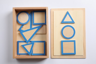 Photo of Set of plane geometric figures with box isolated on white, top view. Montessori toy