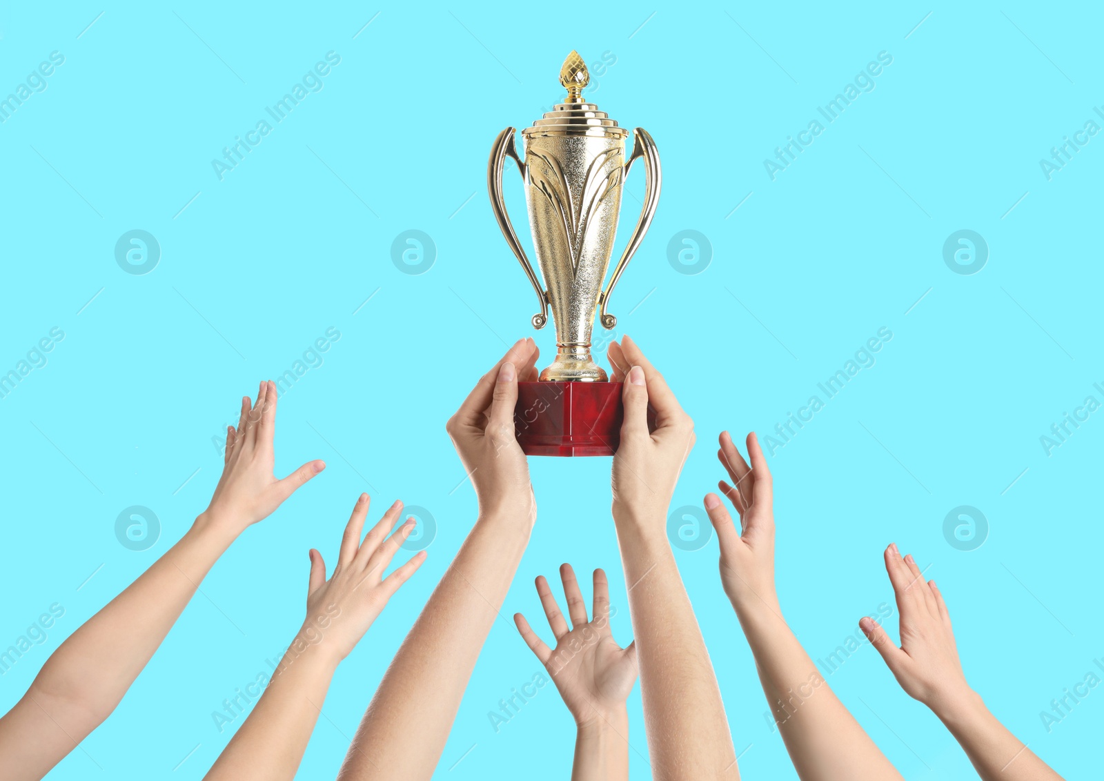 Image of People with golden trophy cup on turquoise background, closeup