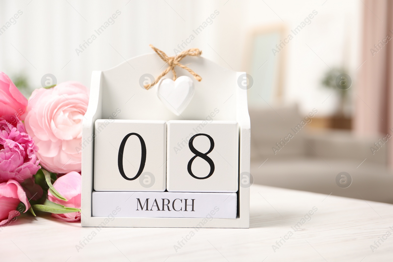 Photo of International Women's day - 8th of March. Block calendar and bouquet of beautiful flowers on white wooden table