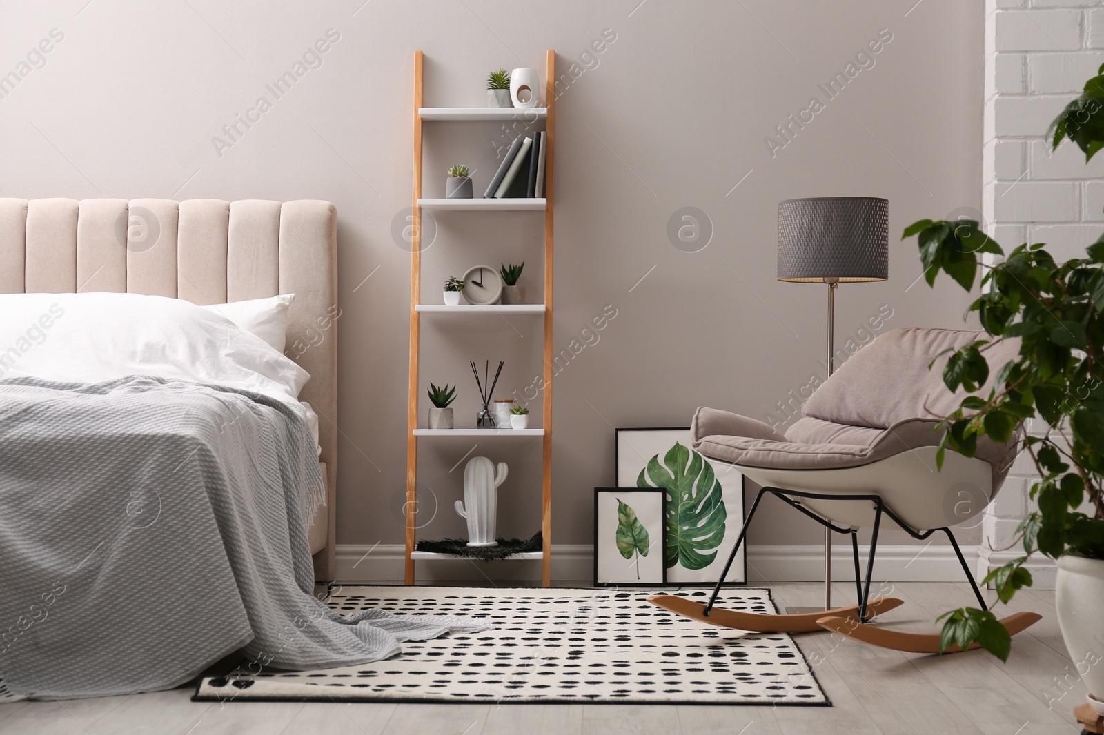 Photo of Stylish bedroom interior with decorative ladder and rocking chair