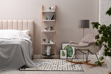 Photo of Stylish bedroom interior with decorative ladder and rocking chair