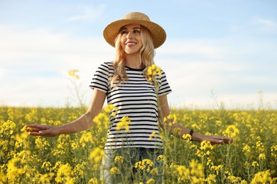 Happy young woman with straw hat in field on spring day