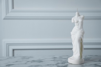 Photo of Stylish Venus De Milo candle on white marble table. Space for text