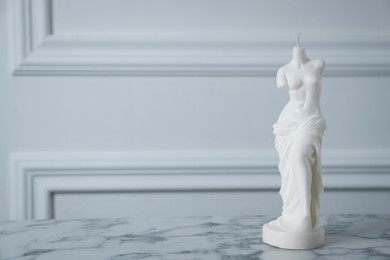 Stylish Venus De Milo candle on white marble table. Space for text