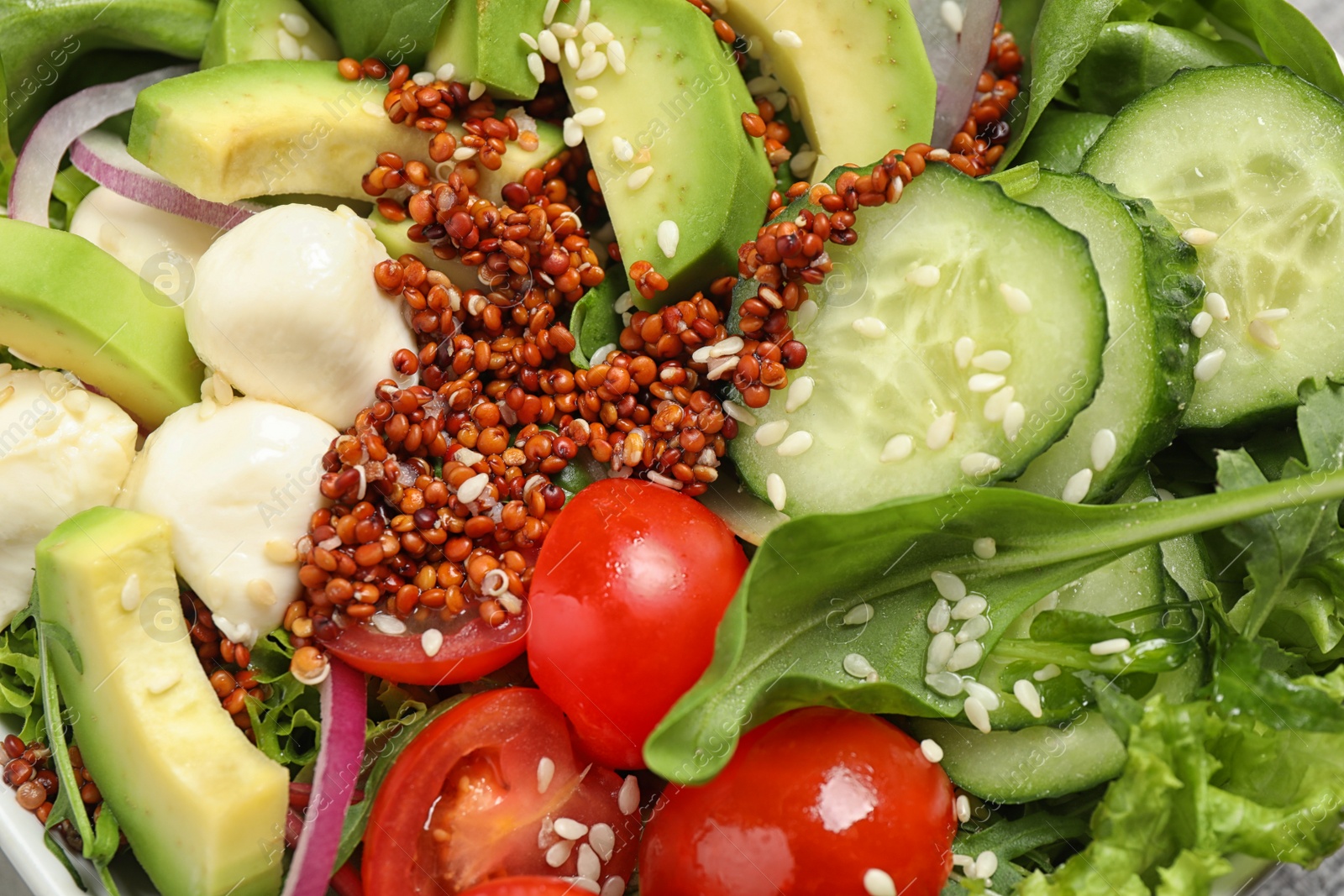 Photo of Delicious avocado salad with quinoa as background, closeup