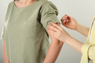 Photo of Diabetes. Woman getting insulin injection on grey background, closeup