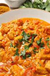 Photo of Delicious chicken curry with parsley on table, closeup