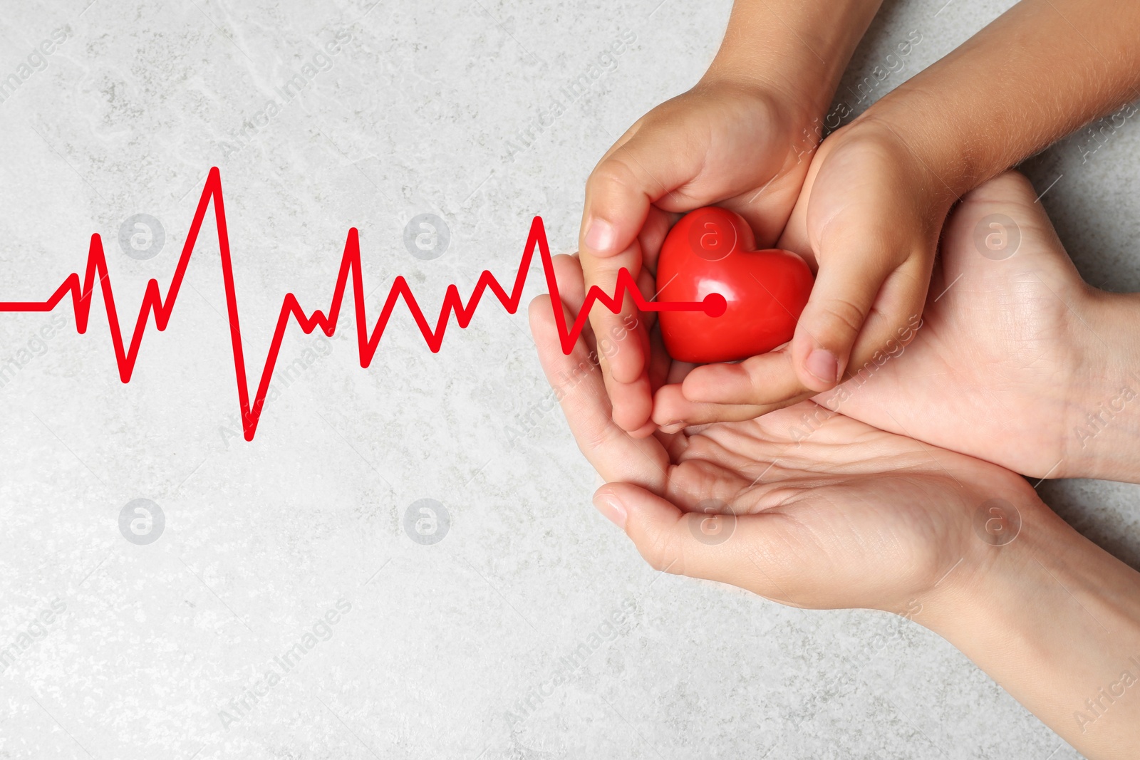 Image of Woman and child holding heart on grey stone background, top view